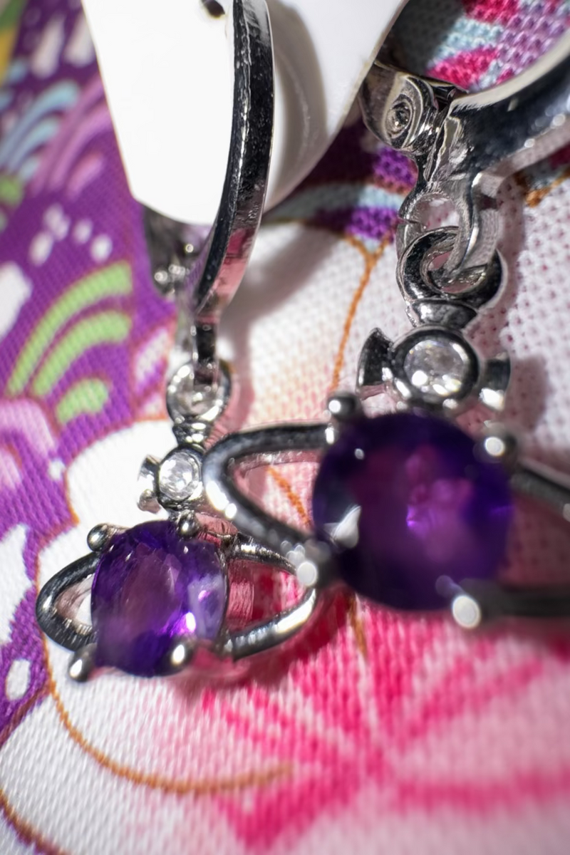 Sterling silver amethyst Saturn dainty huggie earrings with celestial design on a dark background