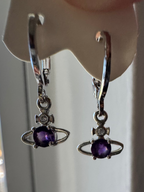 Close-up of sterling silver amethyst Saturn dainty huggie celestial earrings on a dark background