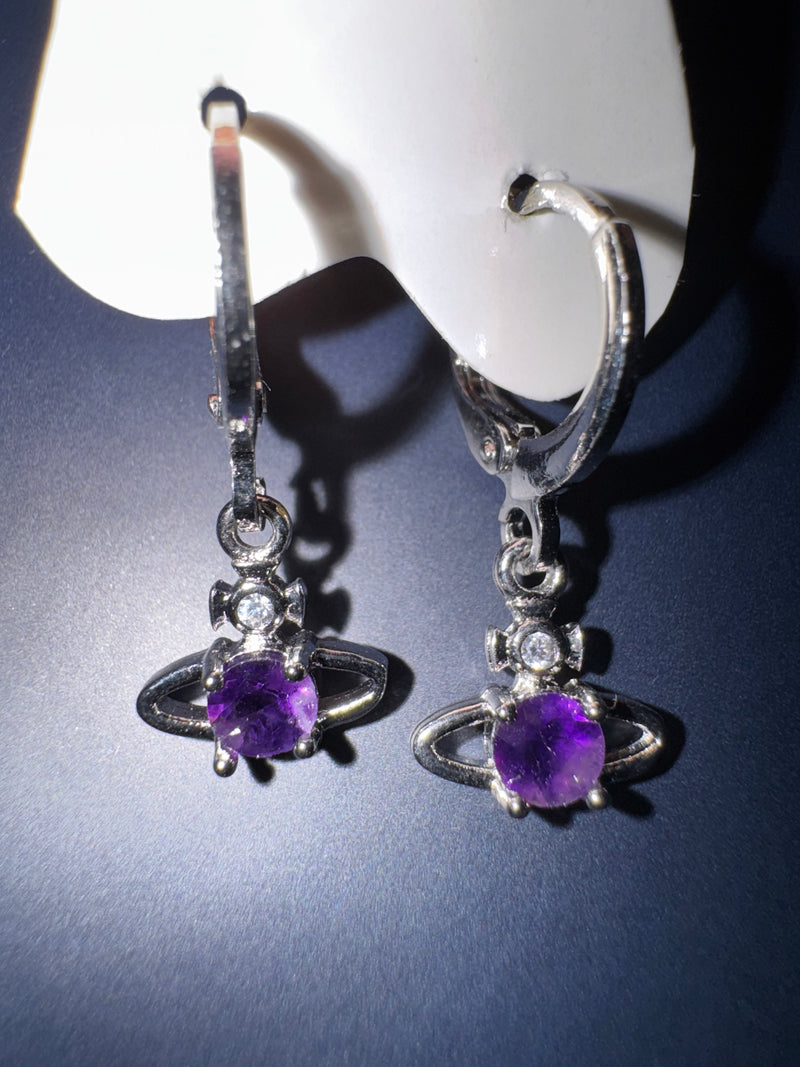 Sterling silver amethyst Saturn celestial huggie hoop earrings on a dark surface