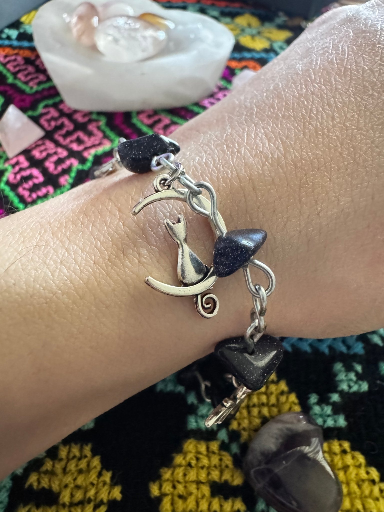 Goldstone charm bracelet with black shimmering beads and creatures of the night charms.