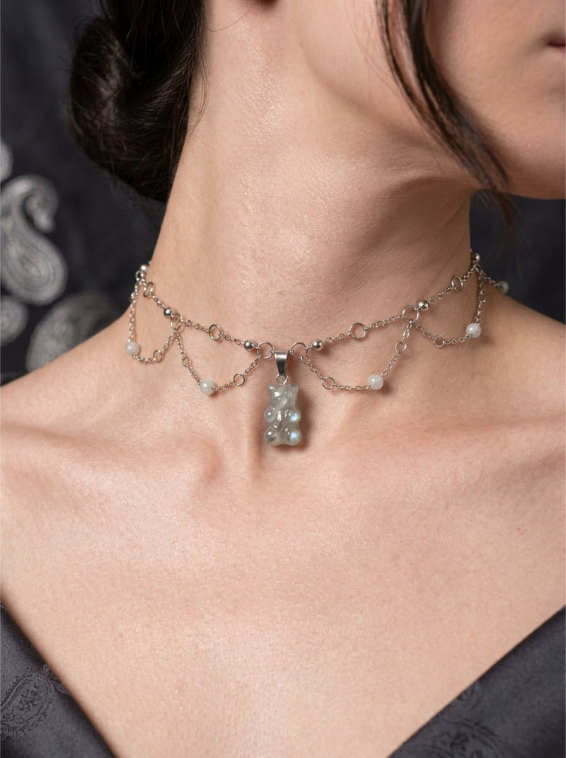 Moss agate crystal gummy bear choker necklace on a dark background
