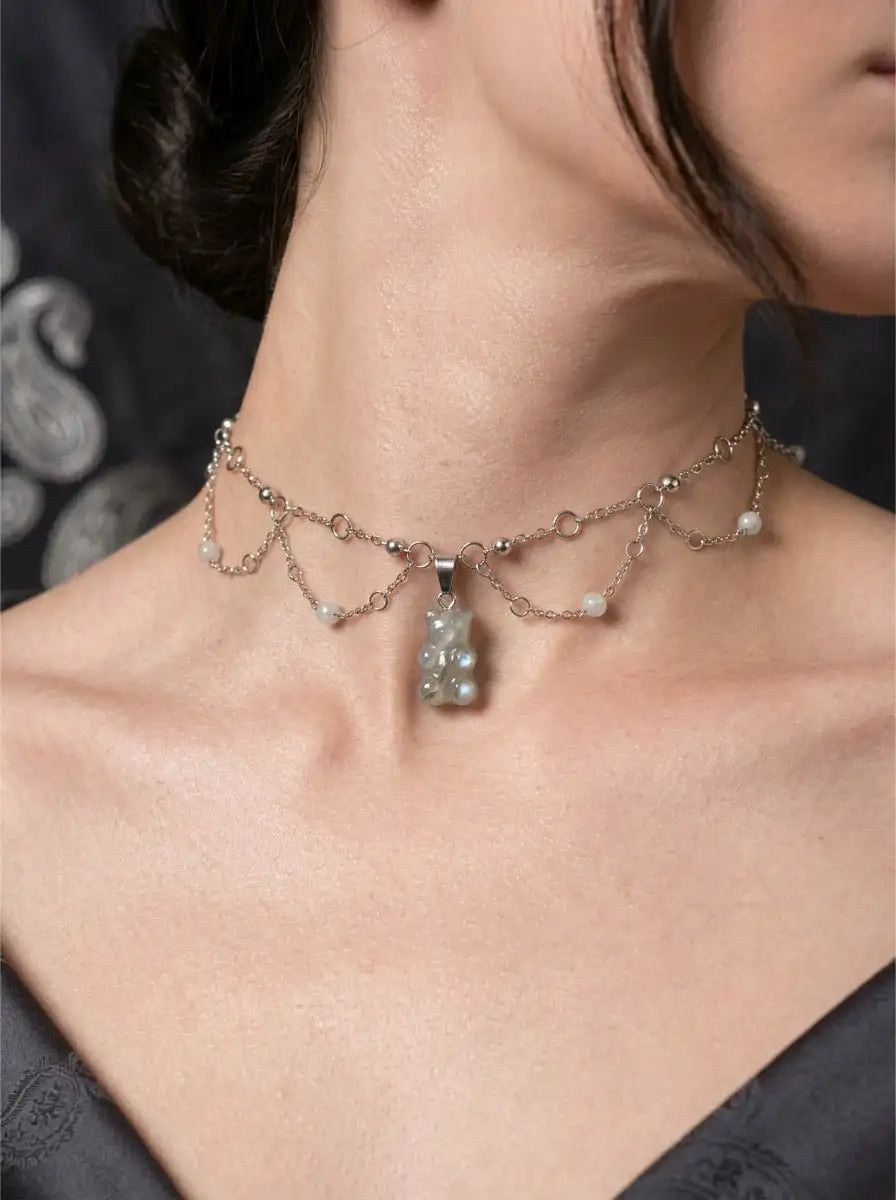 Moss agate crystal gummy bear choker necklace on a dark background
