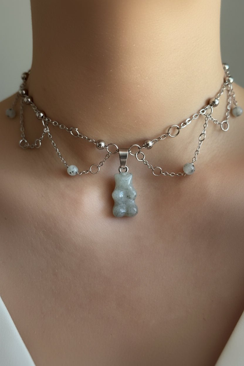 Moss agate crystal gummy bear choker necklace with delicate chain on a dark surface