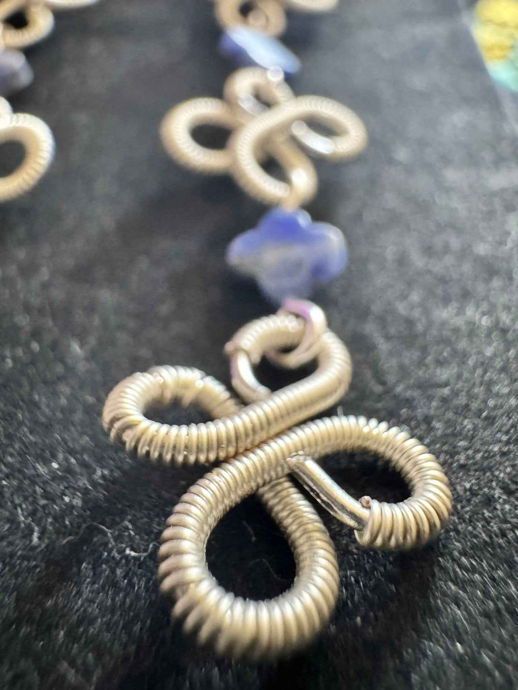 Close-up of silver clover wire wrapped earrings with Lapis Lazuli beads.