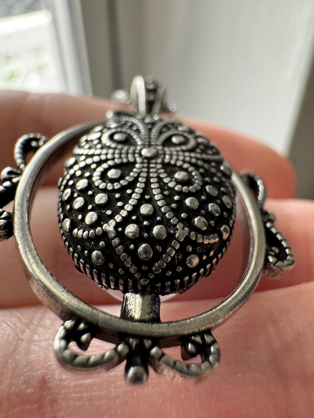 Close-up of Spinning Quartz pendant – rotating crystal mechanism and wire wrap detail by Fractal's Edge Jewels