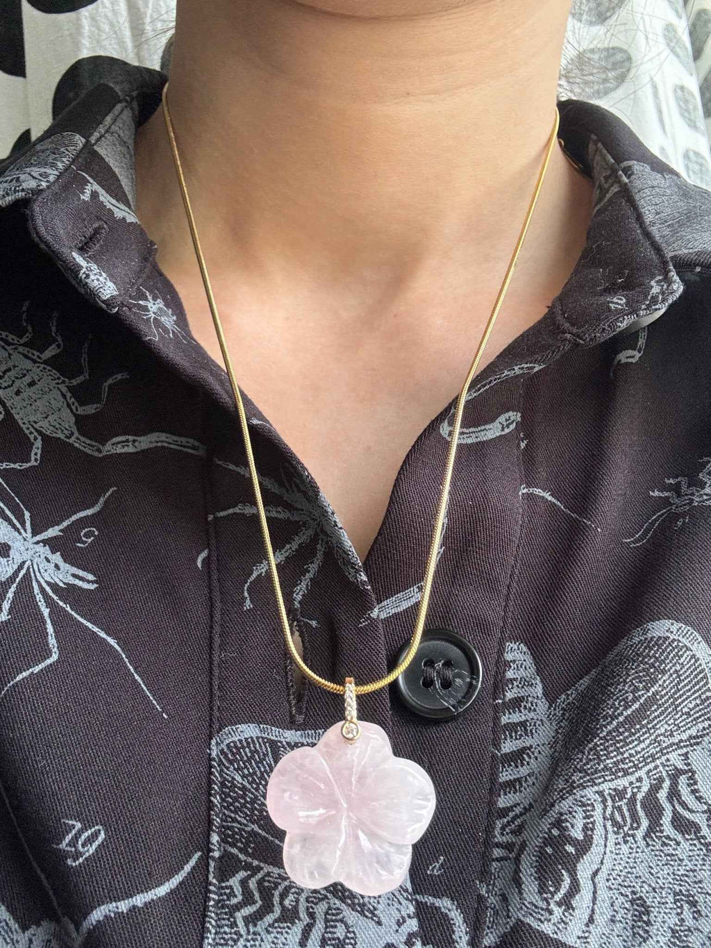 Crystal cherry blossom flower pendant necklace with silver chain on a dark background