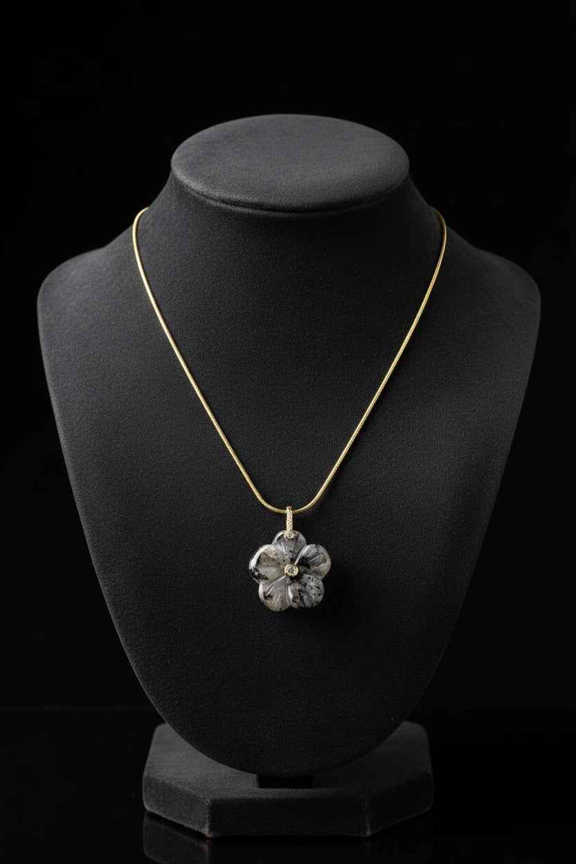 Crystal cherry blossom flower pendant with detailed floral design on a dark surface