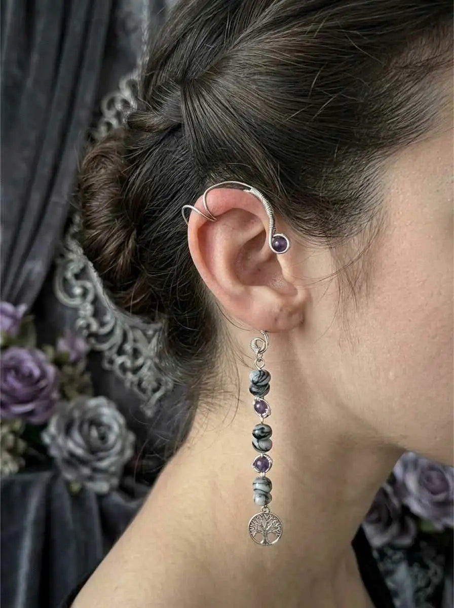 Wire wrapped ear cuff with spiderweb jasper dangle earrings on a dark surface